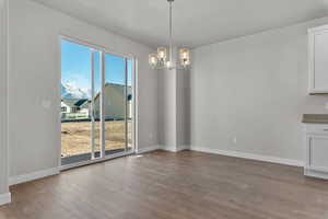 Unfurnished dining area with a chandelier, light wood finished floors, and a mountain view