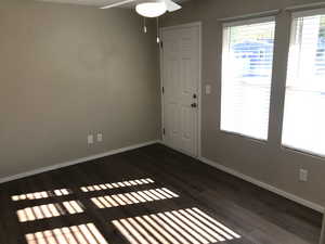 Entrance foyer with a ceiling fan and dark wood-style floors