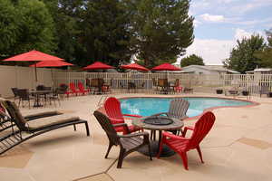 Community pool featuring a patio, outdoor dining area, and an outdoor fire pit
