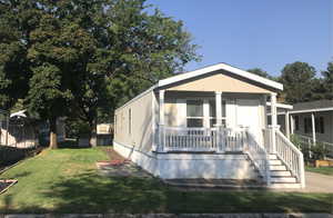 Manufactured / mobile home featuring a front lawn and covered porch
