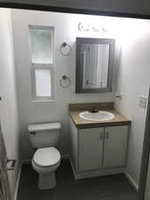 Half bathroom featuring vanity and toilet