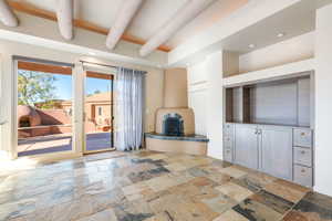 Unfurnished living room featuring recessed lighting, stone tile floors, and beamed ceiling
