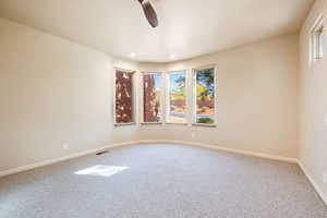 Carpeted spare room with plenty of natural light, recessed lighting, and ceiling fan