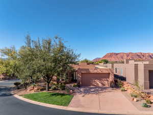 Southwest-style home with a mountain view, stucco siding, driveway, and a garage