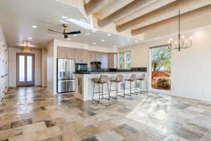 Kitchen featuring stainless steel fridge with ice dispenser, a kitchen breakfast bar, recessed lighting, a peninsula, and pendant lighting