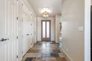 Foyer entrance featuring stone tile floors and baseboards