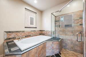Full bath featuring a bath, a shower stall, and recessed lighting