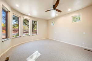 Spare room with carpet, a ceiling fan, and recessed lighting