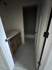 Full bathroom featuring vanity, light tile patterned flooring, and tub / shower combination