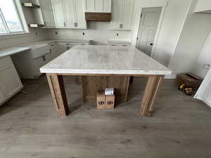 Kitchen with white cabinets, wood finished floors, and a center island