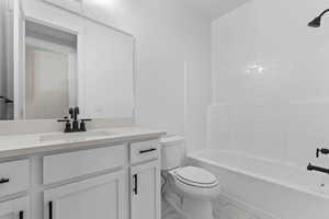 Full bathroom with washtub / shower combination, vanity, and light marble finish floors