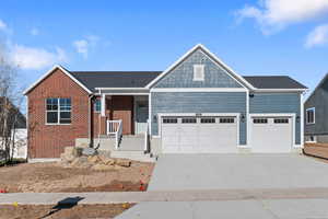 View of front facade featuring a porch, driveway, and an attached garage