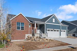 View of front of property featuring covered porch, concrete driveway, brick siding, a shingled roof, and a garage