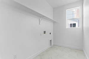 Laundry area featuring hookup for a washing machine, marble look tile flooring, and electric dryer hookup
