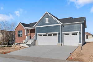 View of front of home featuring concrete driveway and a garage
