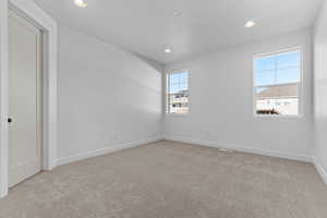 Unfurnished room with light colored carpet and recessed lighting