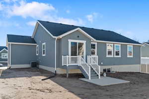 Back of house with roof with shingles, a wooden deck, and a patio area