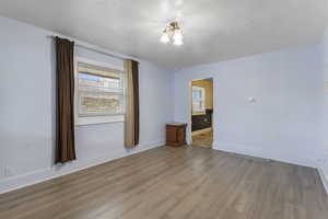 Unfurnished room featuring wood finished floors and a textured ceiling