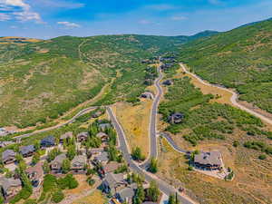 Aerial view of property and surrounding area featuring a mountainous background