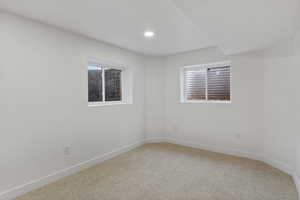 Unfurnished room featuring light colored carpet and baseboards