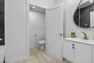 Bathroom with vanity, light wood-style floors, and a tile shower