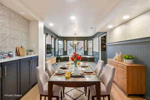 Dining room with light wood-style flooring and recessed lighting