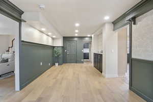 Corridor with light wood-type flooring and recessed lighting