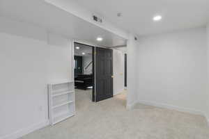 Spare room with light carpet, stairway, and recessed lighting