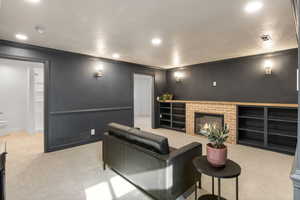 Cinema featuring a brick fireplace, light carpet, recessed lighting, and crown molding