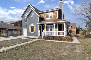 View of front of house with a porch, concrete driveway, an attached garage, a chimney, and roof with shingles