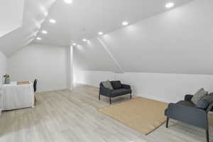 Living area featuring recessed lighting, light wood-style flooring, and vaulted ceiling