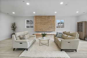 Living area featuring healthy amount of natural light, light wood finished floors, and recessed lighting