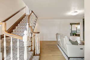 Hall with a decorative wall and light wood-style flooring