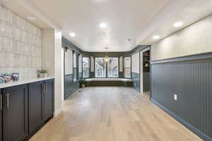 Corridor featuring light wood-style floors, recessed lighting, and a chandelier