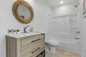 Full bath with vanity, bathtub / shower combination, and light tile patterned flooring
