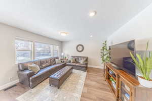 Family room with light wood-style flooring, a textured ceiling, and recessed lighting