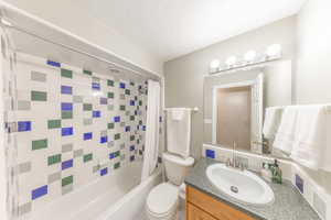 Full bath with shower / bath combination with curtain, vanity, and a textured ceiling