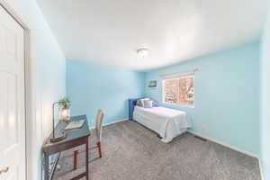 Bedroom with carpet and a textured ceiling