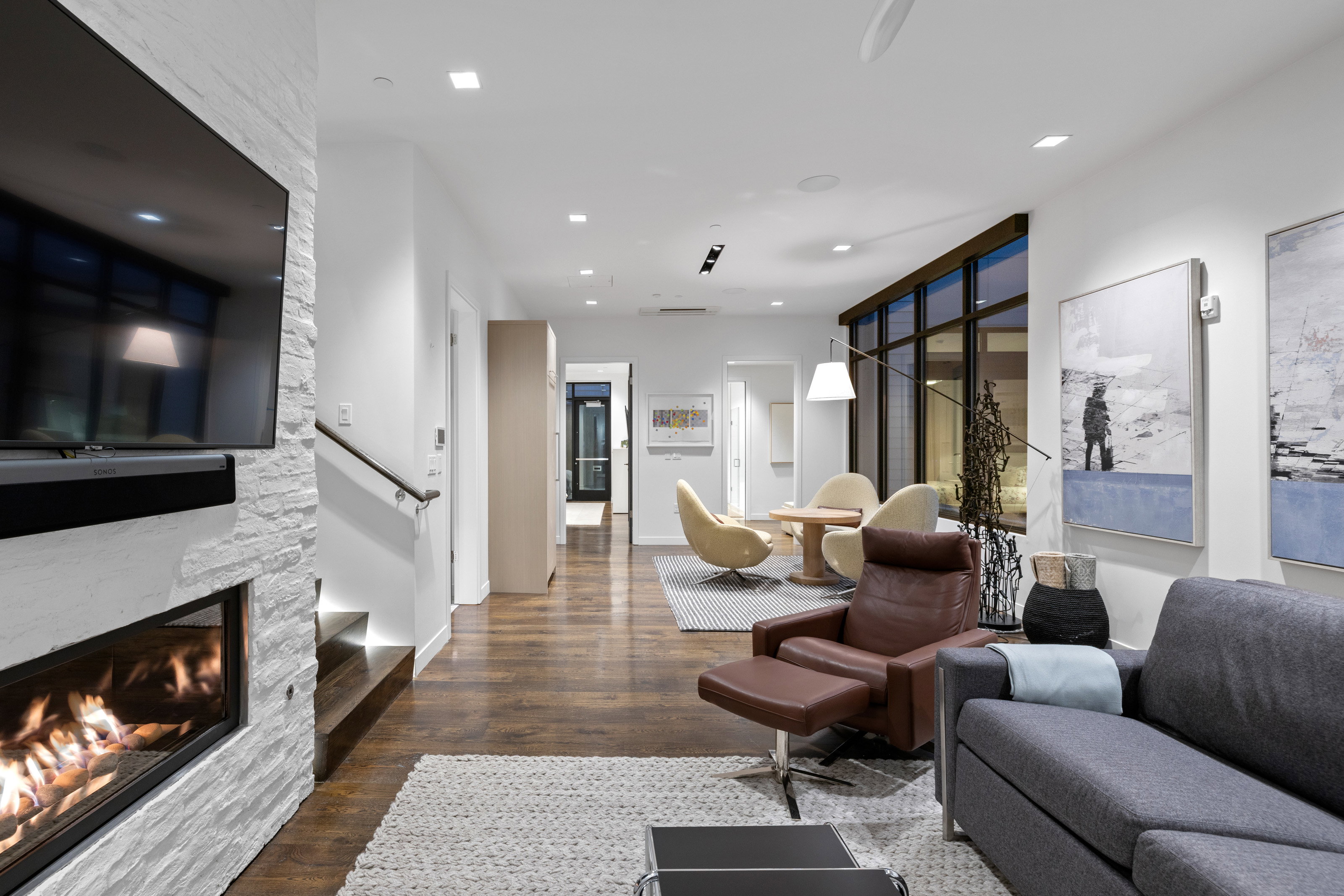 Living area featuring wood finished floors, a stone fireplace, and recessed lighting