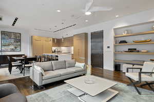 Living area featuring dark wood-type flooring and a ceiling fan