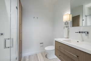 Bathroom with vanity, light wood finished floors, and a shower with door