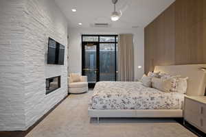 Bedroom with access to exterior, a ceiling fan, and a multi sided fireplace