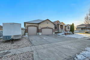 Ranch-style house featuring a garage, stucco siding, and driveway