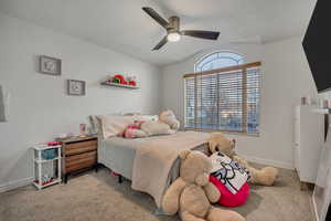 Bedroom featuring light colored carpet, a ceiling fan, and vaulted ceiling