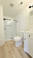 Full bath featuring vanity, light wood finished floors, and a shower stall