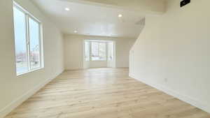 Empty room featuring light wood-type flooring and recessed lighting