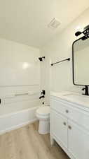 Full bathroom featuring vanity, light wood finished floors, and washtub / shower combination