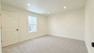 Spare room with light carpet and recessed lighting