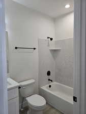 Full bathroom with vanity, washtub / shower combination, light wood-style floors, and recessed lighting