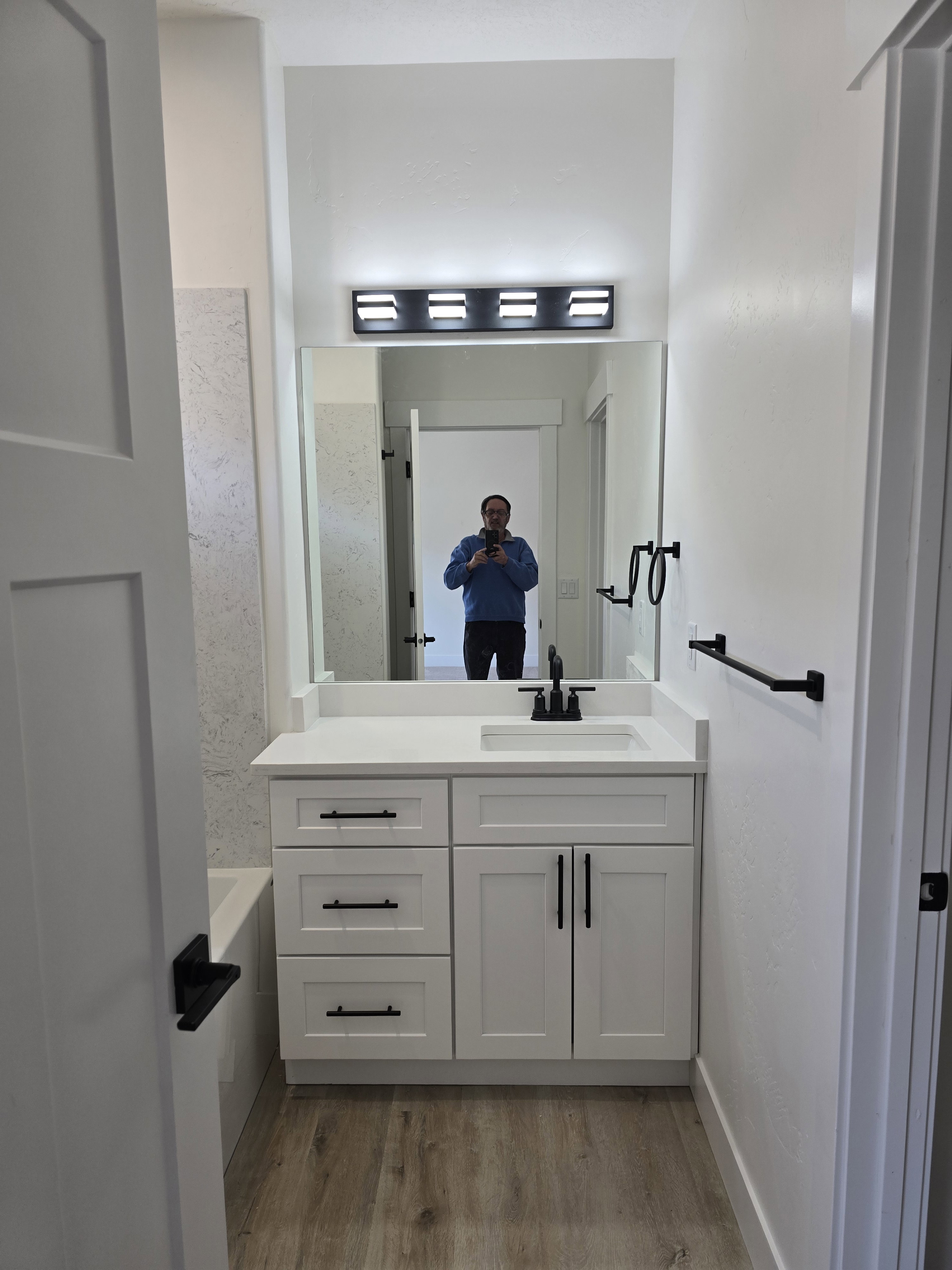 Bathroom featuring a bathtub, vanity, and light wood-style floors